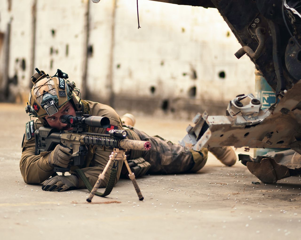 The Art of Drawing Readers In: Your attractive post title goes here A soldier in tactical gear lying prone with a rifle in an urban setting, showcasing military readiness.