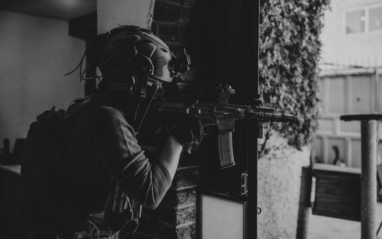 Crafting Captivating Headlines: Your awesome post title goes here Black and white image of a soldier aiming a rifle in an urban setting, wearing tactical gear.