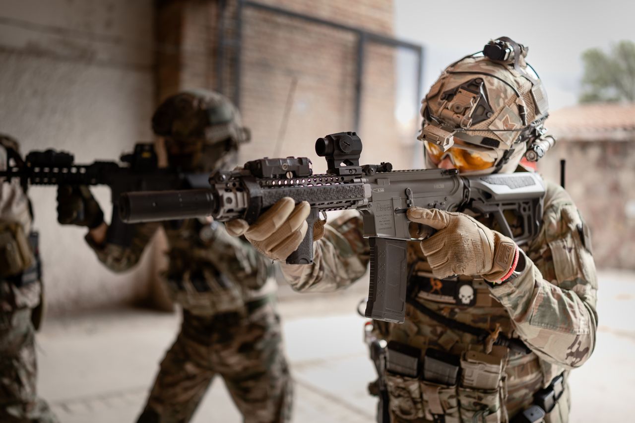 Armored soldiers in action during indoor training exercises, equipped with tactical gear.